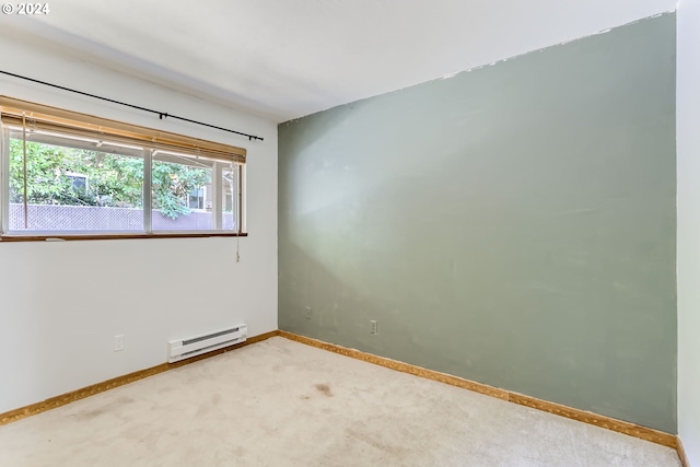 carpeted spare room featuring a baseboard radiator