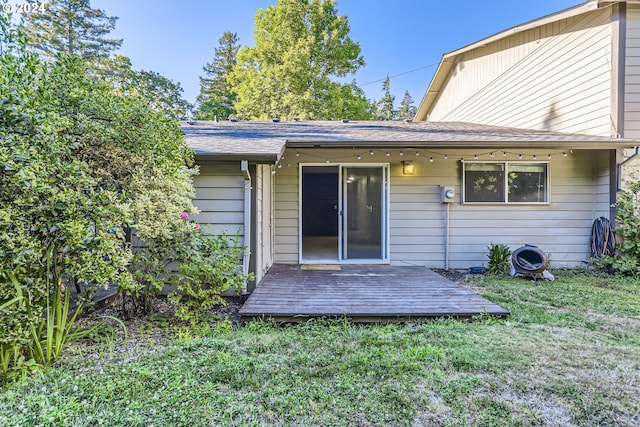 back of house featuring a wooden deck and a yard