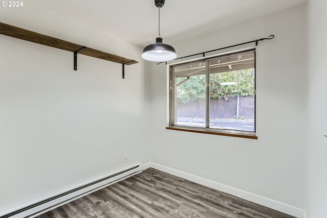 spare room with a baseboard heating unit and hardwood / wood-style floors