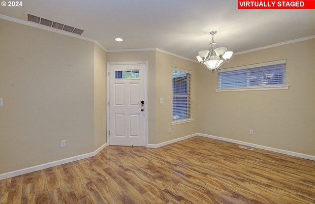 foyer featuring a chandelier, crown molding, and hardwood / wood-style flooring