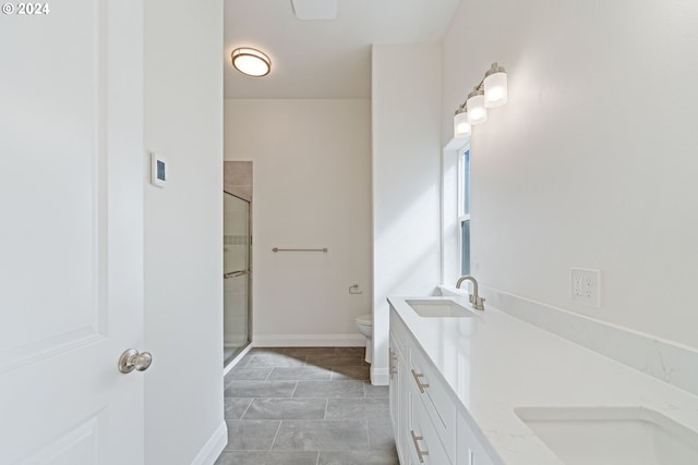 bathroom with tile patterned floors, vanity, toilet, and a shower with door