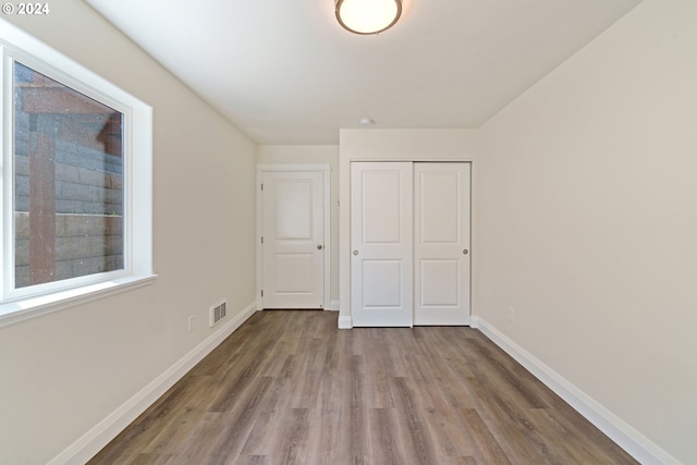 unfurnished bedroom with a closet and light wood-type flooring