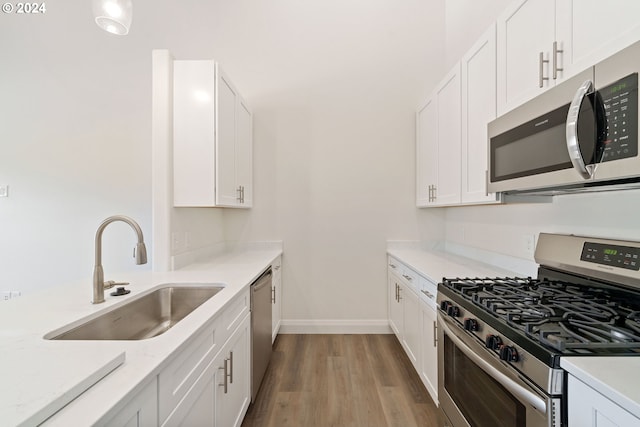 kitchen featuring sink, light hardwood / wood-style flooring, white cabinets, and appliances with stainless steel finishes