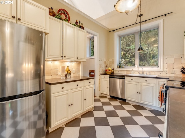 71465 Northshore Dr, Birkenfeld, OR 97016 - kitchen featuring appliances with stainless steel finishes, dark flooring, dark countertops, decorative backsplash, and hanging light fixtures