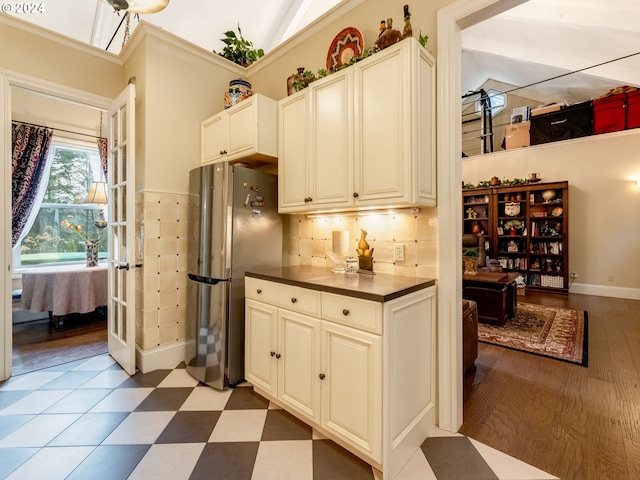 kitchen with light hardwood / wood-style floors, tasteful backsplash, stainless steel refrigerator, and vaulted ceiling