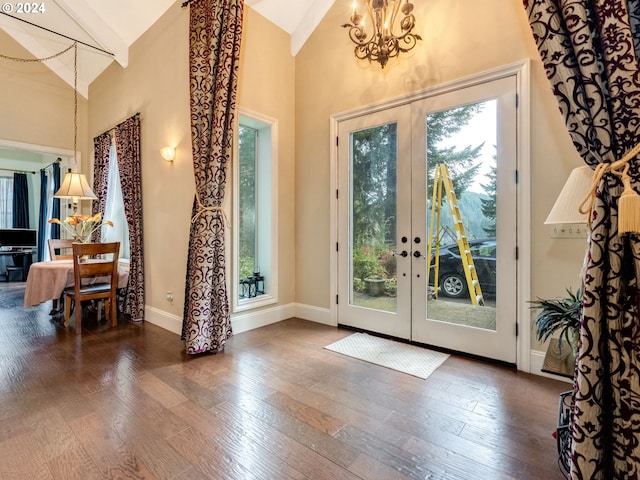 doorway with french doors, high vaulted ceiling, dark wood-type flooring, and a notable chandelier