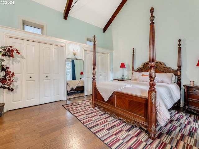 bedroom featuring beamed ceiling, high vaulted ceiling, and light wood-type flooring