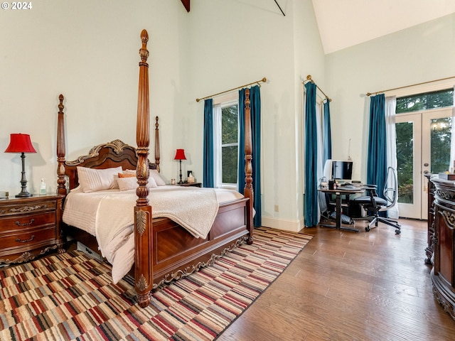 bedroom featuring access to exterior, wood-type flooring, french doors, and multiple windows