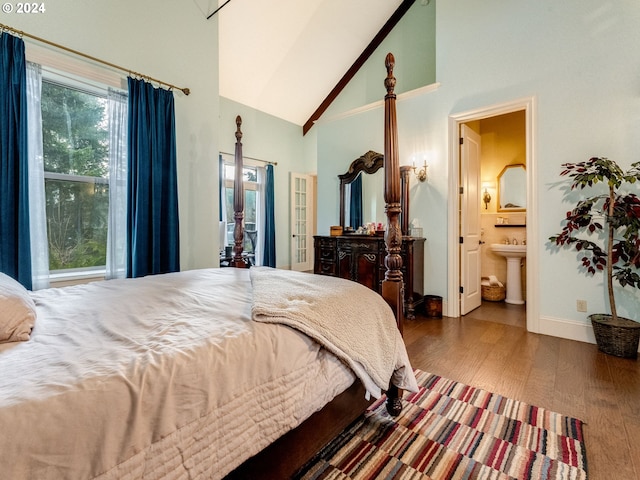 bedroom featuring connected bathroom, sink, high vaulted ceiling, and dark wood-type flooring