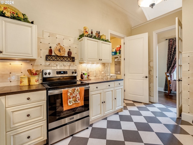 kitchen with lofted ceiling, stainless steel range with electric cooktop, and tasteful backsplash