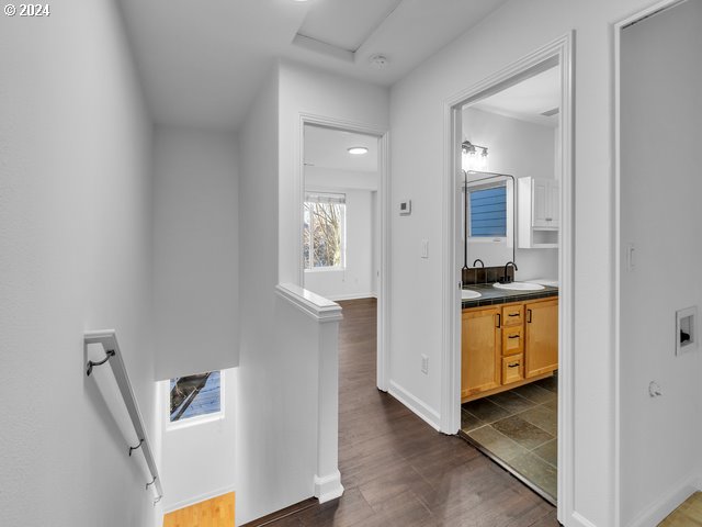 corridor with dark hardwood / wood-style floors and sink