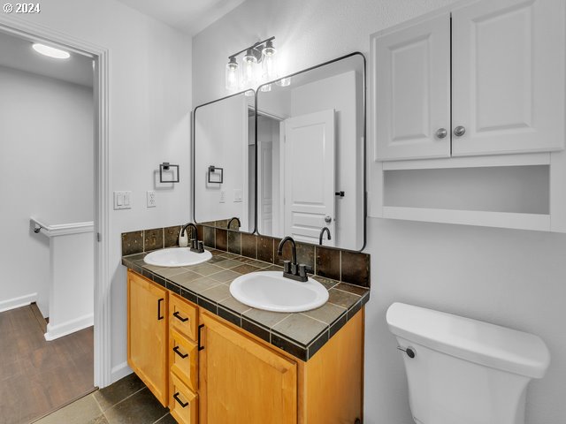 bathroom with vanity, hardwood / wood-style flooring, and toilet