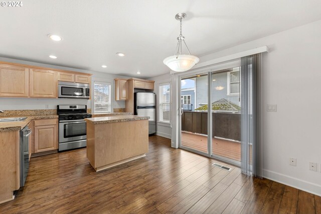 kitchen with dark hardwood / wood-style floors, stainless steel appliances, and light brown cabinets