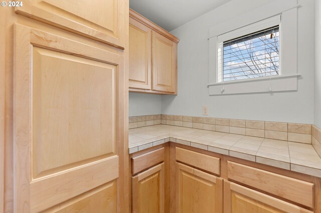 kitchen featuring tile counters and light brown cabinetry