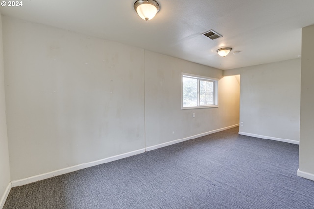 unfurnished room featuring dark carpet