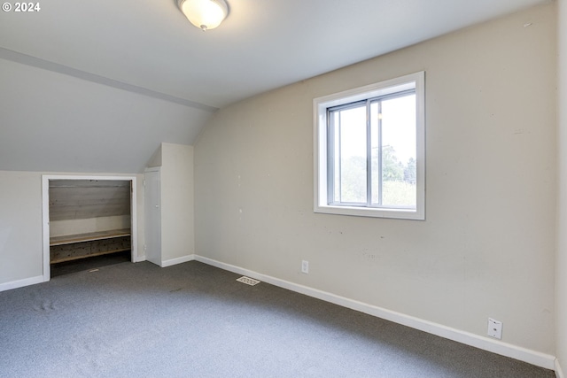 bonus room featuring vaulted ceiling and dark carpet