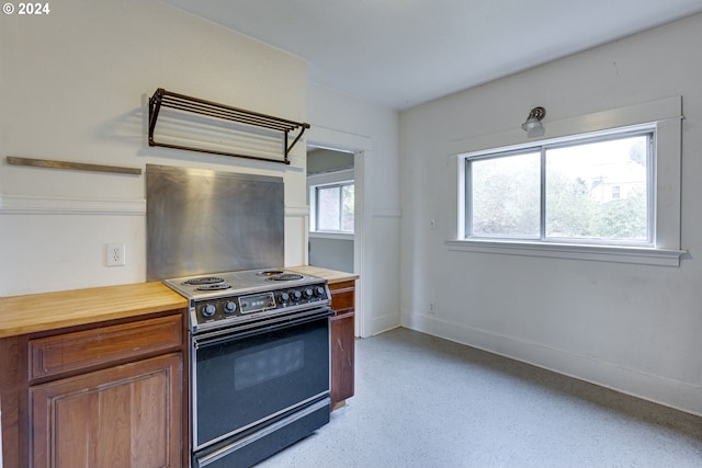 kitchen featuring butcher block counters, electric range oven, and range hood