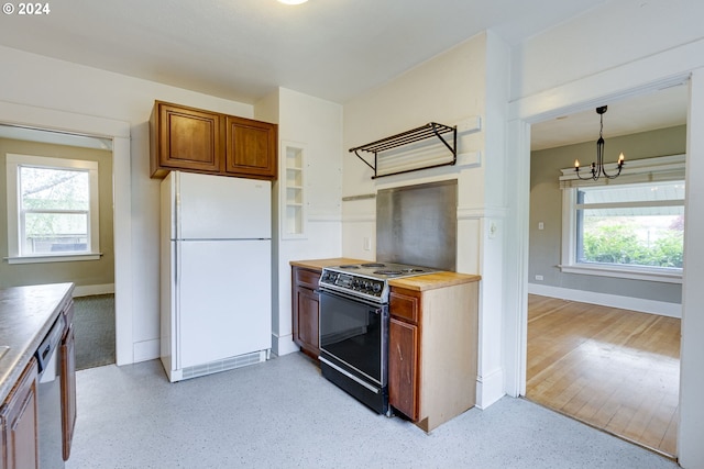 kitchen with electric range oven, plenty of natural light, white refrigerator, decorative light fixtures, and stainless steel dishwasher