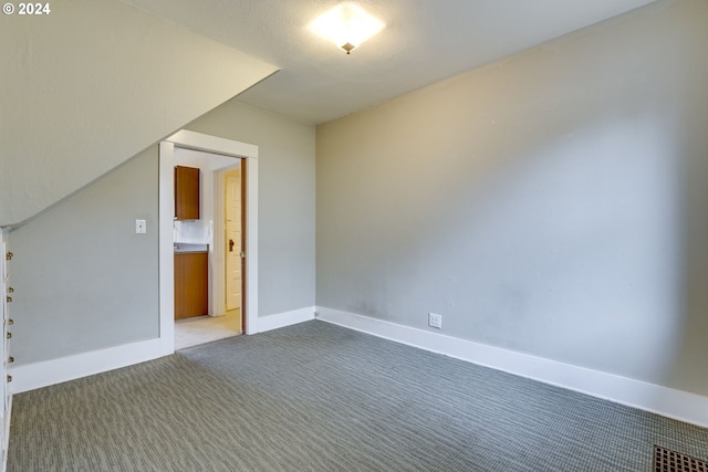 bonus room featuring dark carpet