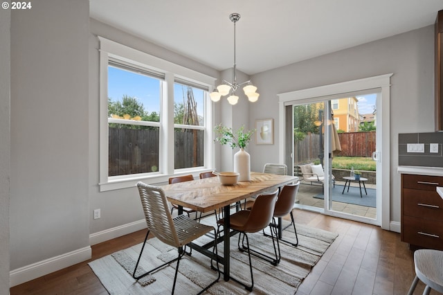 dining space featuring a chandelier, dark wood-type flooring, and plenty of natural light