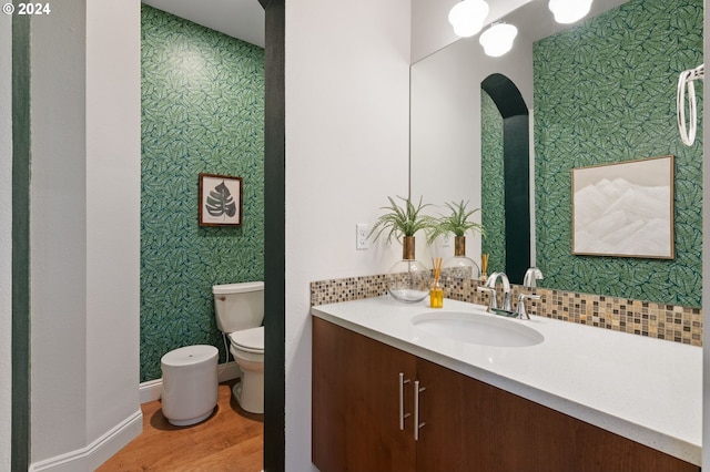 bathroom with wood-type flooring, vanity, and toilet