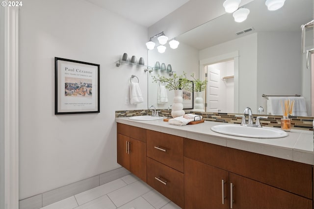 bathroom with tile patterned floors, vanity, and tasteful backsplash