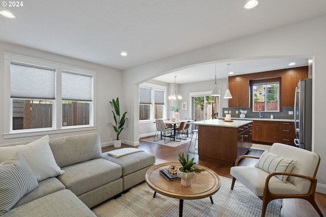 living room featuring an inviting chandelier, hardwood / wood-style floors, and sink