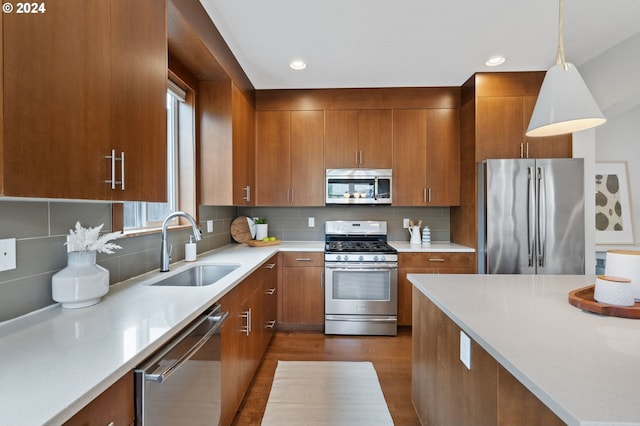 kitchen with appliances with stainless steel finishes, dark hardwood / wood-style floors, sink, and a wealth of natural light