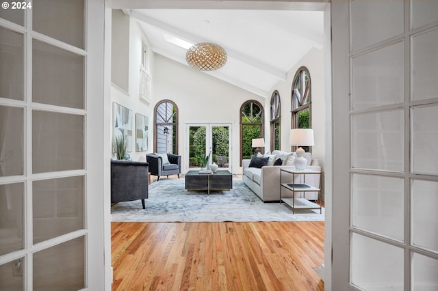 living room featuring french doors, high vaulted ceiling, beam ceiling, and hardwood / wood-style floors