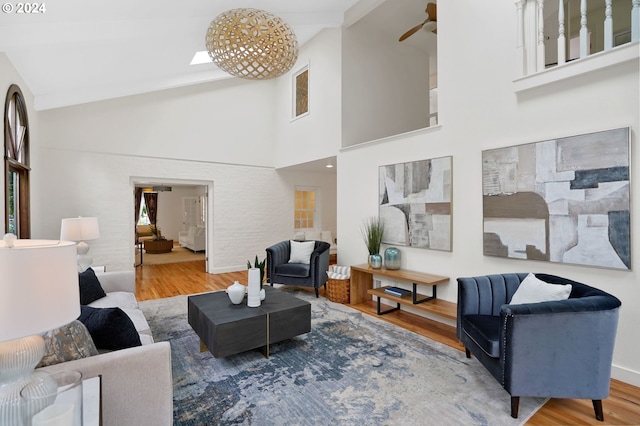 living room featuring ceiling fan, hardwood / wood-style floors, and high vaulted ceiling