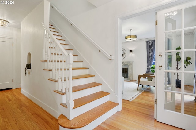 stairs featuring a chandelier and wood-type flooring