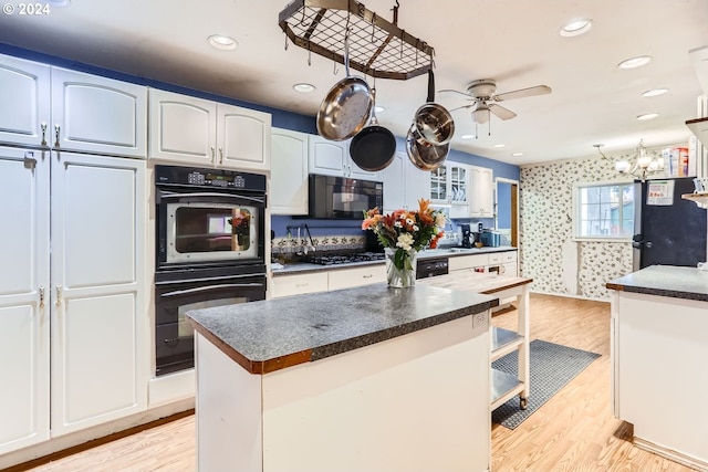 kitchen featuring black appliances, ceiling fan, a kitchen island, white cabinets, and light wood-type flooring