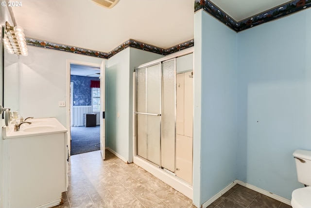 bathroom featuring toilet, vanity, and an enclosed shower