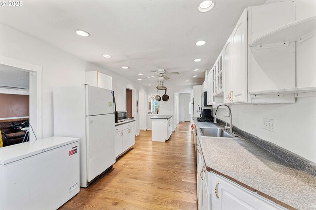 kitchen with freestanding refrigerator, recessed lighting, white cabinetry, and fridge