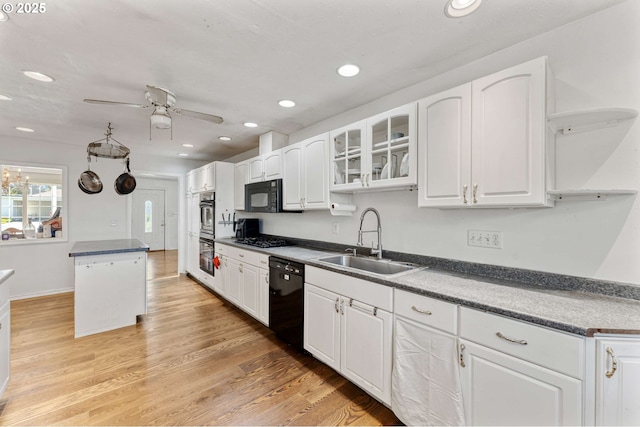 kitchen featuring white cabinetry, a ceiling fan, a sink, and black appliances