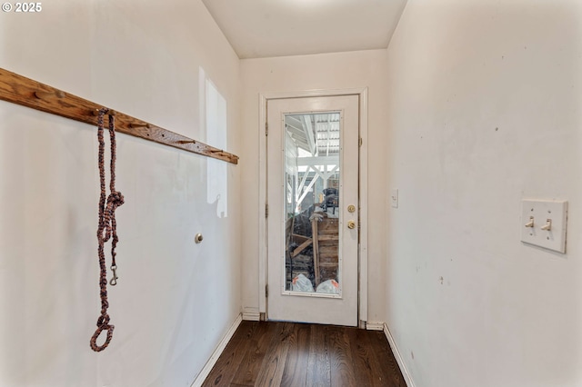 doorway featuring baseboards and dark wood-style floors