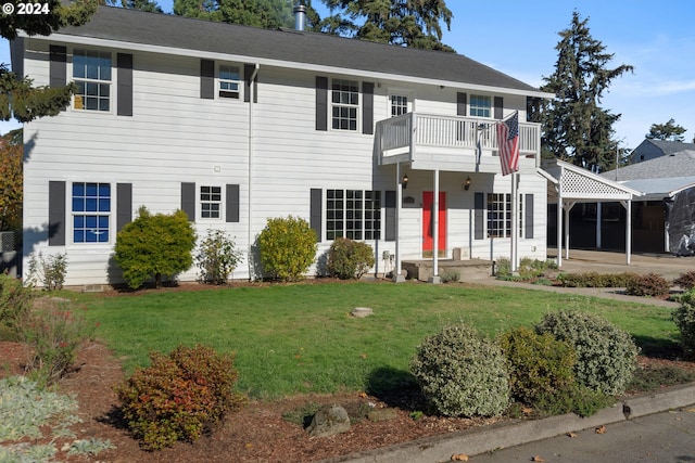 colonial inspired home featuring a front lawn and a balcony