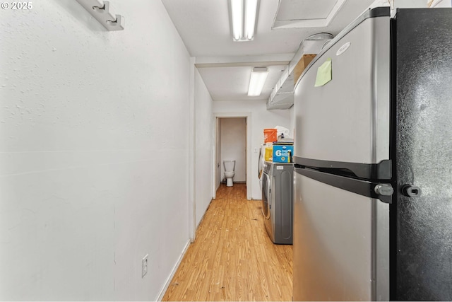 hall featuring light wood-style flooring and washer and clothes dryer
