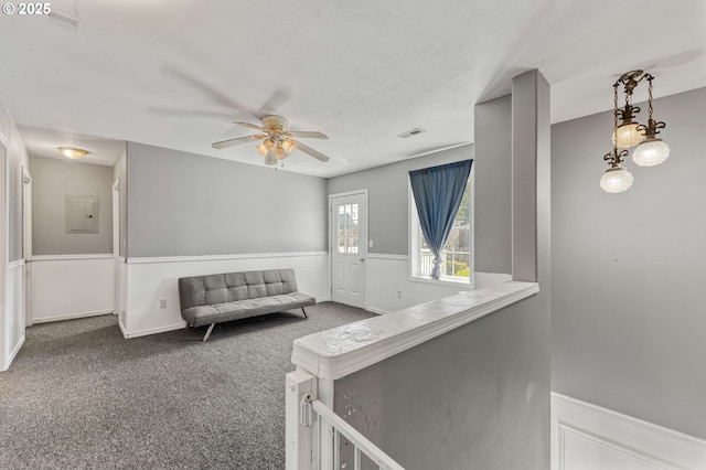 hall featuring carpet floors, electric panel, and visible vents