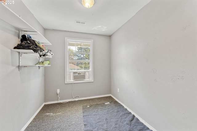 carpeted spare room with baseboards, visible vents, and cooling unit