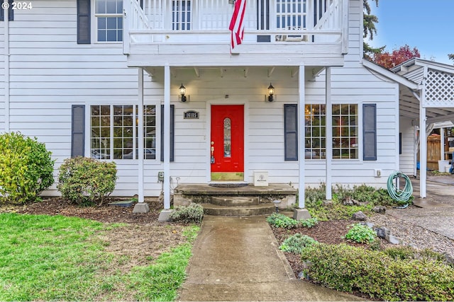 view of exterior entry with a balcony