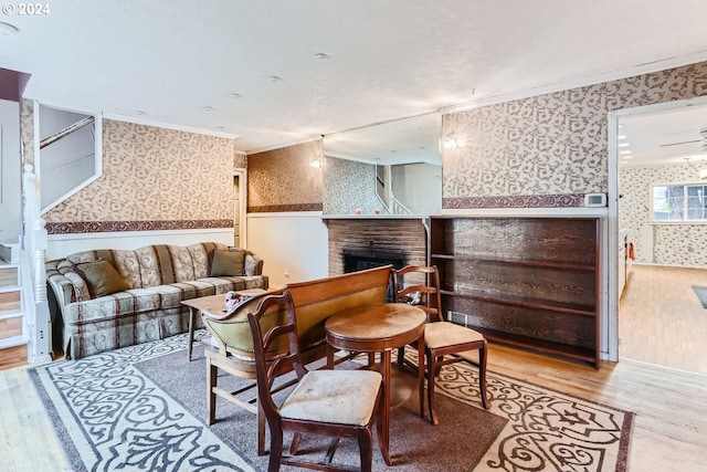 living room with a fireplace, light hardwood / wood-style floors, and ornamental molding