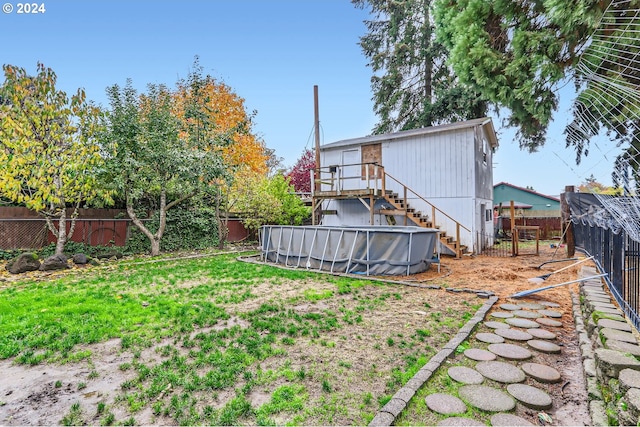 view of yard featuring a fenced in pool, a fenced backyard, and stairs