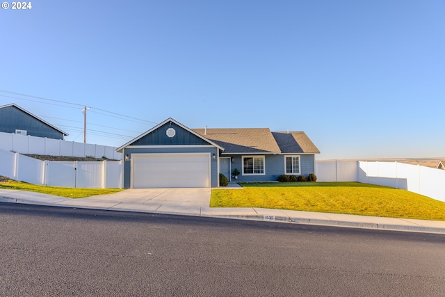 view of front of property with a garage and a front lawn