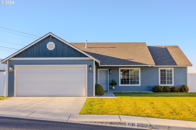 ranch-style house featuring a garage and a front lawn