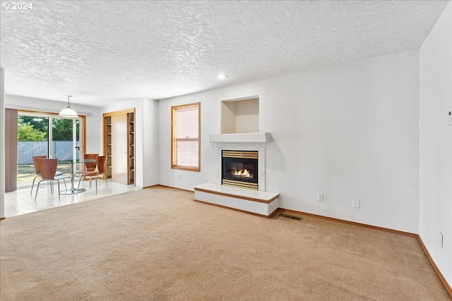 unfurnished living room featuring a textured ceiling and carpet