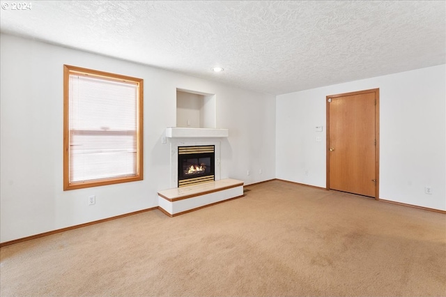 unfurnished living room with light carpet and a textured ceiling