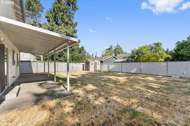 view of yard with a storage shed and a patio