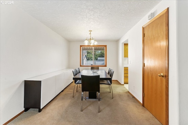 dining space featuring light carpet, an inviting chandelier, and a textured ceiling