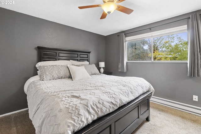 carpeted bedroom featuring baseboard heating and ceiling fan